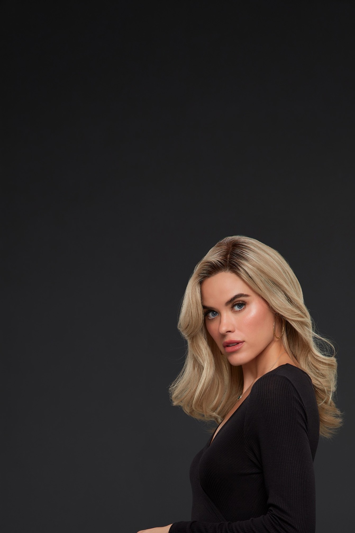 Model wearing a long blonde wig from Jon Renau collection, styled with flowing layers and a natural appearance.
